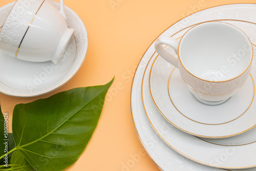 Porcelain tea cup with a golden line decoration and a saucer with clipping path. on colour background