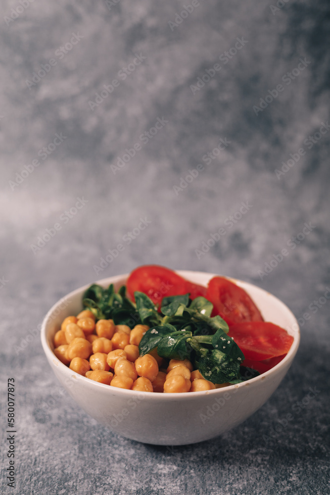 veggie poke filled with chickpeas, arugula and tomato, copy space, vertical shot veggie poke filled with chickpeas, arugula and tomato, copy space, vertical shot