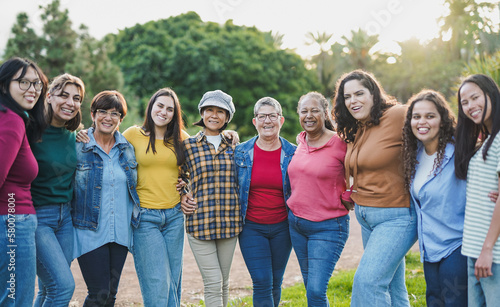Group of multi generational women hugging each other while smiling on camera - Diverse women concept