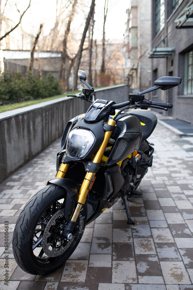 a sporty black and yellow motorcycle is street