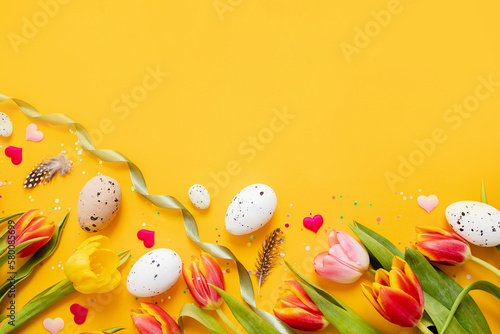 Photography beautiful festive layout with tulip, confetti and easter eggs on a bright yellow background