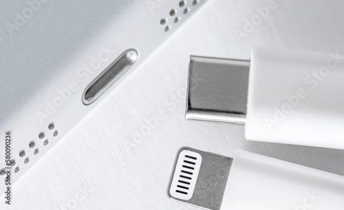 Apple Lightning to USB-C cable on the gradient white background, close up. Technology concept.