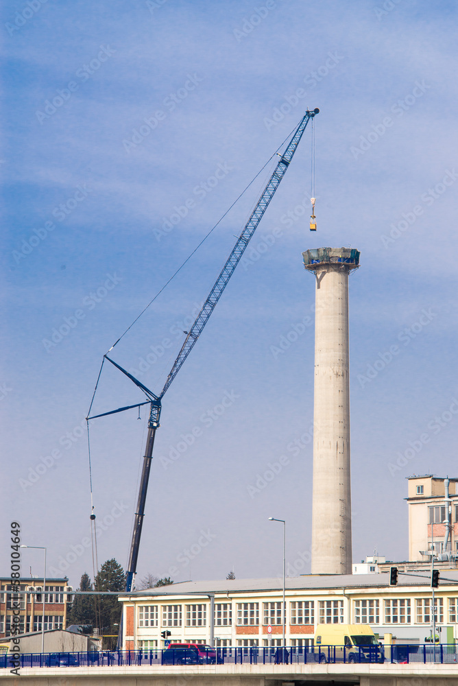 Zubri Czech Rep 1st March 2021 DISMANTLE OF CONCRETE INDUSTRIAL CHIMNEY using a crane and a little excavator. Scene with public traffic passing under the chimney