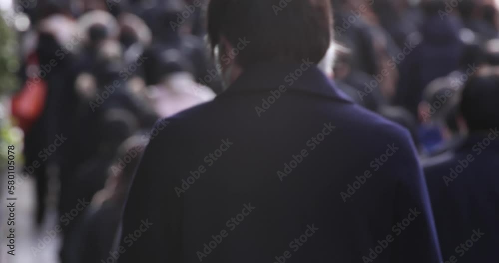 A crowd of walking people on the city street defocused A crowd of walking people on the city street defocused