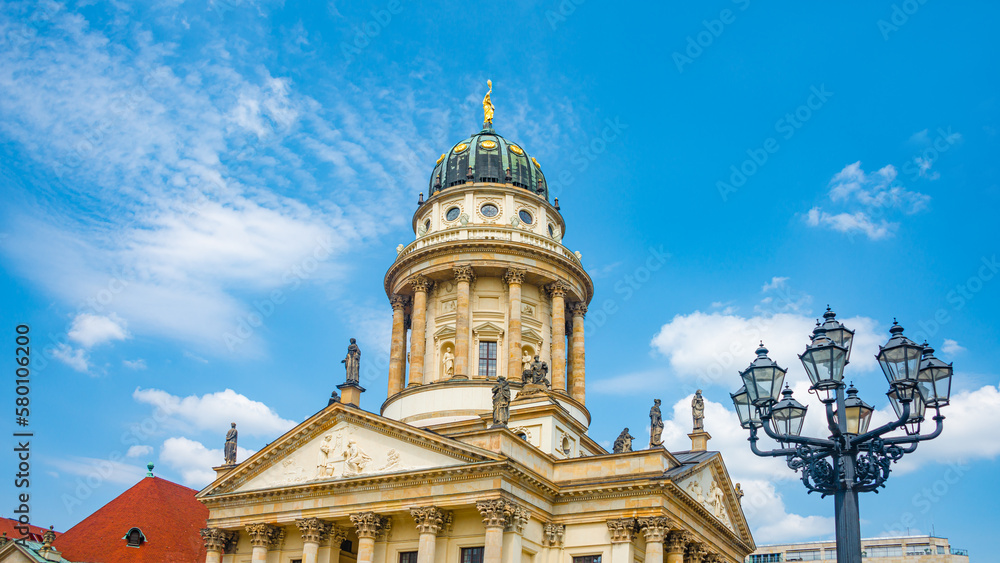 View over the Gendarmenmarkt in Berlin and French Cathedral in historical and business downtown, Berlin, Germany, at summer sunny day and blue sky.