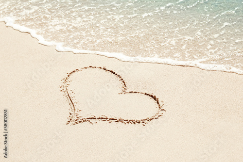 beautiful drawings inscription on the sand of the sea in the summer on the nature