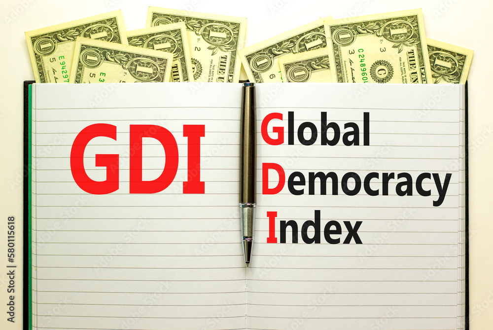 GDI global democracy index symbol. Concept words GDI global democracy index on white note on beautiful background from dollar bills. Pen. Business and GDI global democracy index concept. Copy space.