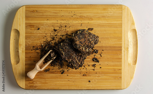 Chinese white Puer tea close up. Background of white tea briquette on a wooden board. photo