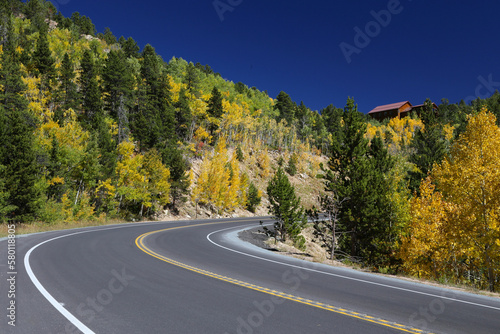 Curvy mountain road with colorful yelloe aspen trees of Colorado in autumn
