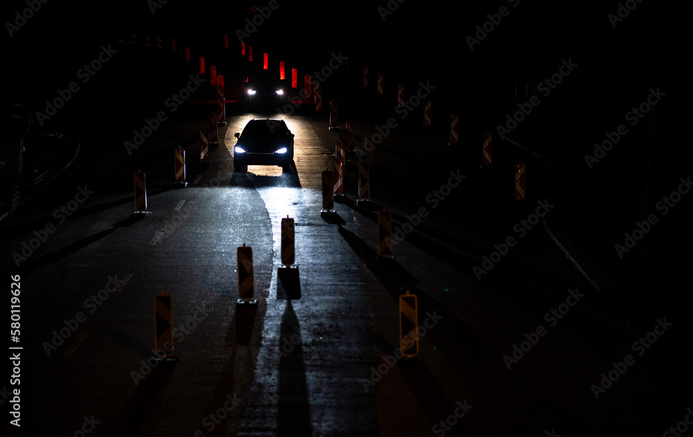 Cars on a road with roadworks. Works on the road. Night traffic. - obrazy, fototapety, plakaty 