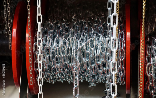 Silver metal chains wound on a reel and displayed for sale photo