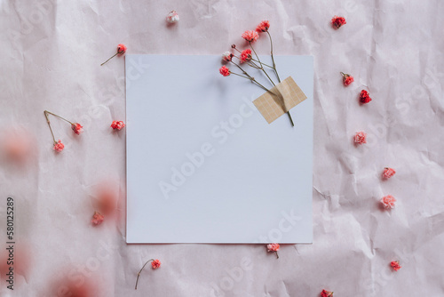 Mock up of blank white card on crumpled background with dry flowers.