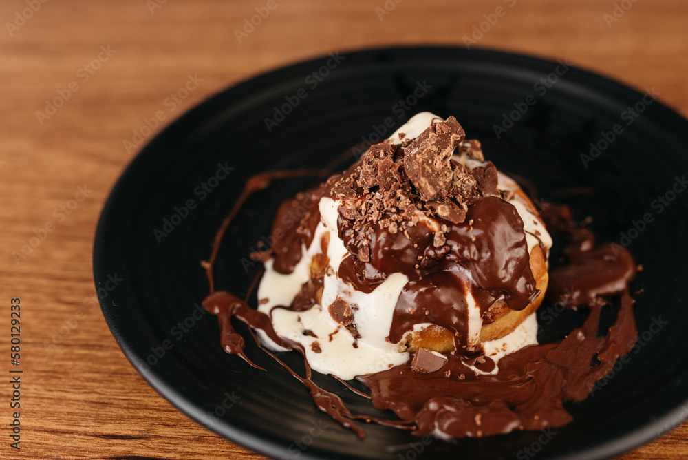 Dessert - Sonho - Typical Brazilian sweet produced in bakeries - Bread sprinkled with sugar and stuffed with vanilla cream, with chocolate sauce and ice cream - obrazy, fototapety, plakaty 