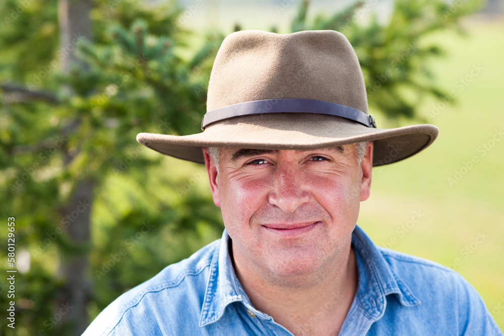 Close up portrait of mature man wearing hat outdoors.