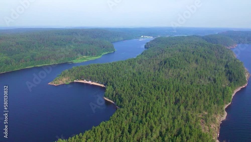 Top view of a large blue lake and islands covered with green coniferous forest. The nature of Karelia, the natural landscape. Camp on the shore of the lake. Flying over a beautiful place. photo