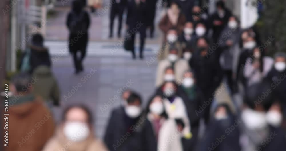A crowd of walking people on the city street defocused A crowd of walking people on the city street defocused