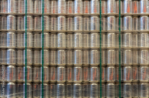 Background with a pallet of empty aluminum cans wrapped in film in a warehouse