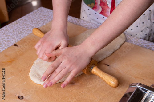 The process of rolling out the dough by a girl at home. Prepares Neapolitan sfogliatella at home, for his family. the concept of cooking gourmet dishes at home. real people