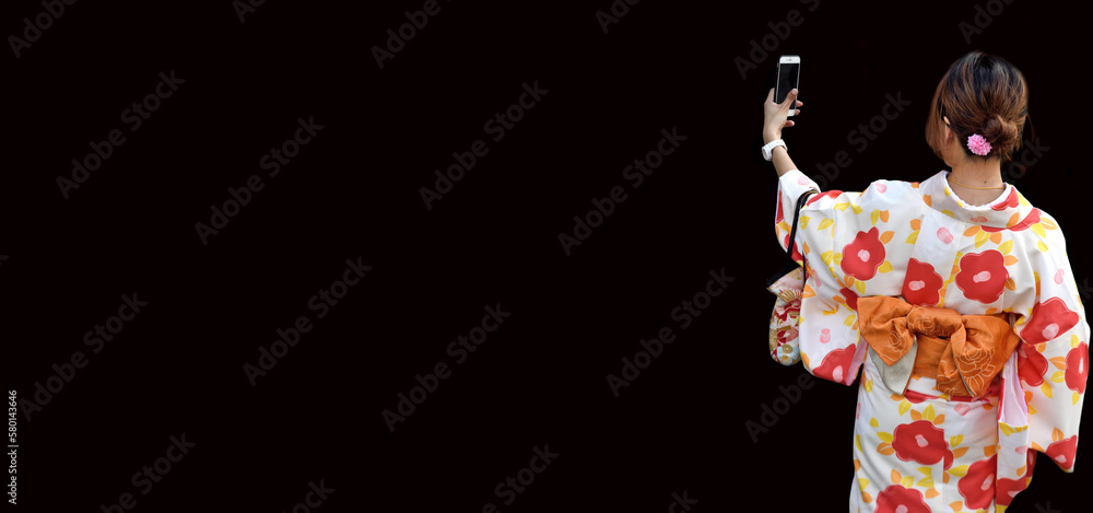 Japanese woman taking selfie, black background with copy space.