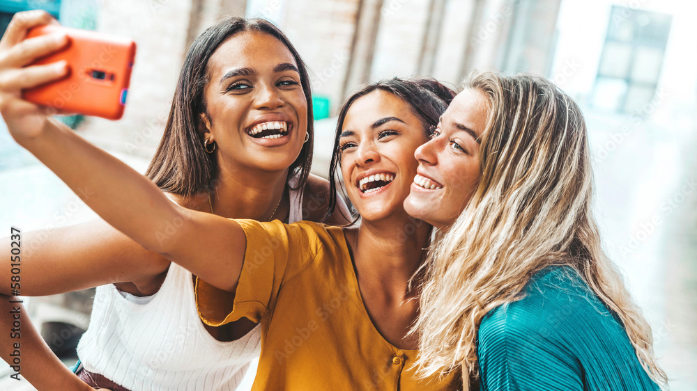 Happy female friends taking selfie picture with smart mobile phone device outside - Three young women having fun hanging out in city street - Teenagers addicted to social media - Youth lifestyle