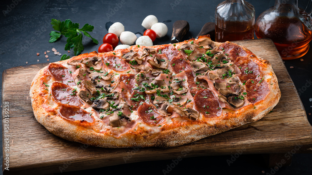 Italian food pinza or pizza with sausage, ham, mushrooms, cheese and herbs.