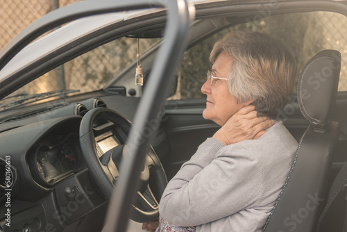 Senior woman having neck pain while driving a car. Old woman feeling bad about an injury, transportación, vehículo, chófer