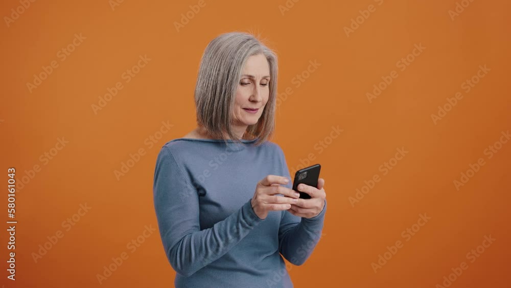 Woman looks at mobile phone and shows thumb-up approvingly Woman looks at mobile phone and shows thumb-up approvingly