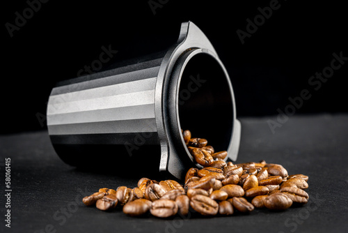 Wallpaper Mural Dosing cup with black matte texture. Top view on black background with coffee beans. Barista tool for dosing coffee beans and using it to when grinding beans. Focus on the beans in the center.. Torontodigital.ca