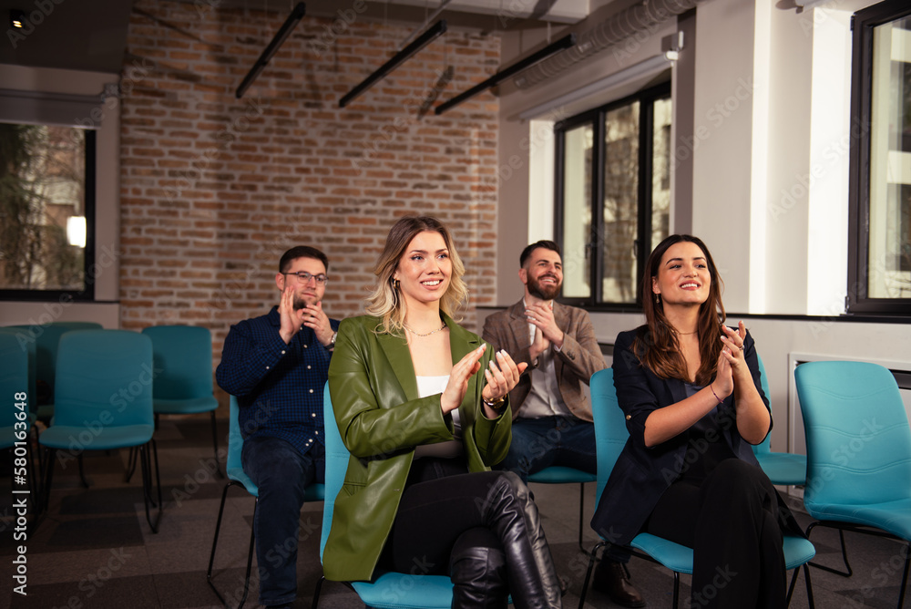 Smiling audience applauding at a business seminar Smiling audience applauding at a business seminar