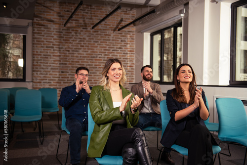 Smiling audience applauding at a business seminar