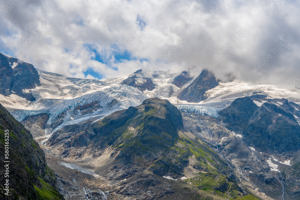 View of mountains with snow remnants in summer in Swiss Alps