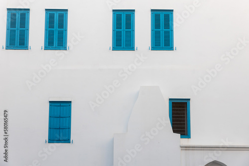Blue windows with shutters on white wall. mediterranean style