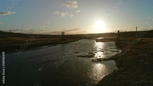 Puente en el atardecer sobre el lago, reflejo de la luz del sol en el lago 