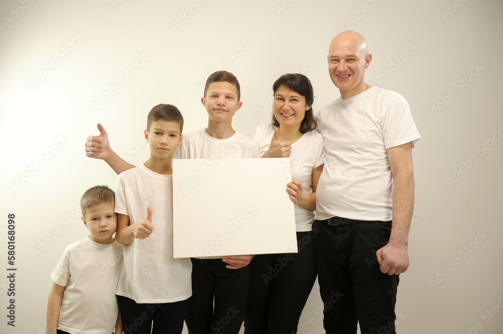 Group of young multi-ethnic beautiful people wearing white shirts, posing together with empty white board. Cheerfull smiling friends. High quality photo Group of young multi-ethnic beautiful people wearing white shirts, posing together with empty white board. Cheerfull smiling friends. High quality photo