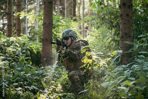 A modern warfare soldier on war duty in dense and dangerous forest areas. Dangerous military rescue operations © .shock