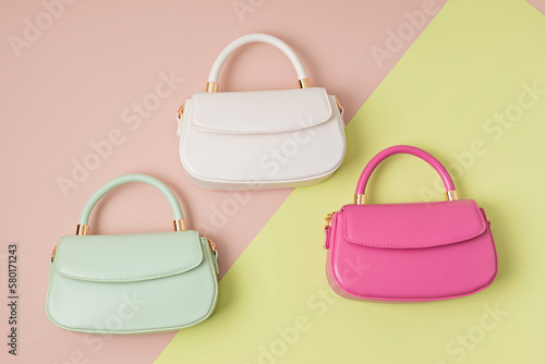 Three pastel colored womens hand bags on pink background
