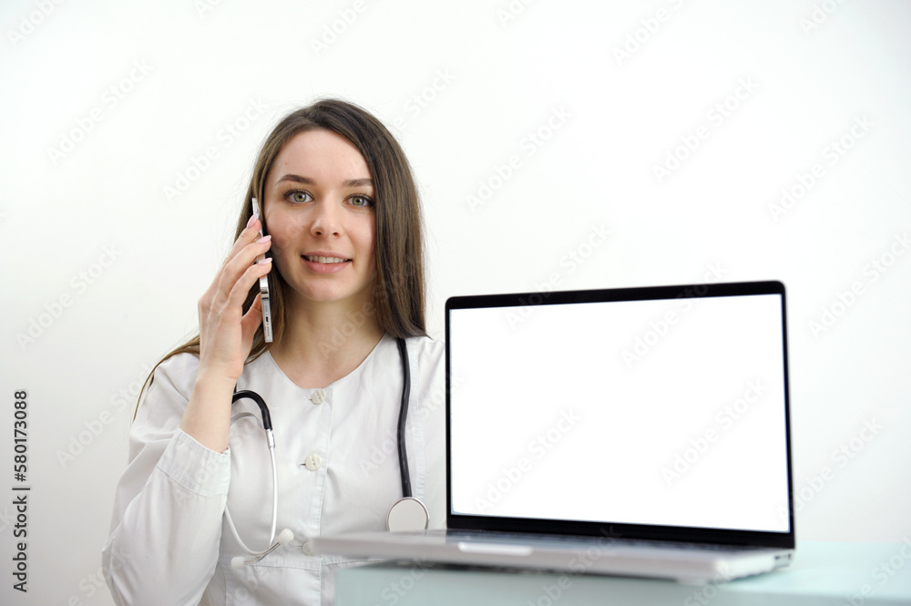 Female medical assistant wears white coat, headset video calling distant patient on laptop. Doctor talking to client using virtual chat computer app. Telemedicine, remote healthcare services concept Female medical assistant wears white coat, headset video calling distant patient on laptop. Doctor talking to client using virtual chat computer app. Telemedicine, remote healthcare services concept