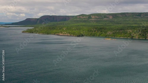 Aerial view of blue water Lake Superior with green Canadian coastline Sleeping Giant Silver Islet Evergreen Trees Mountain Cliffs in background