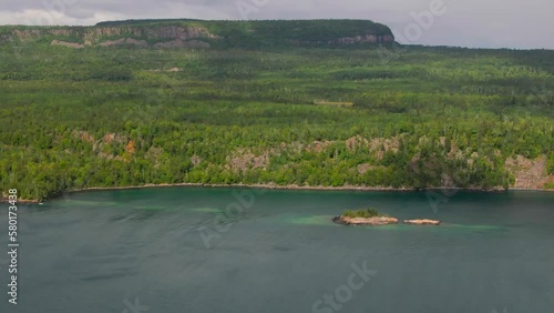 Aerial view of blue water Lake Superior with green Canadian coastline Sleeping Giant Silver Islet Evergreen Trees Mountain Cliffs in background