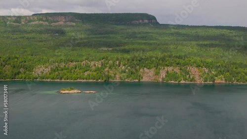 Aerial view of blue water Lake Superior with green Canadian coastline Sleeping Giant Silver Islet Evergreen Trees Mountain Cliffs in background
