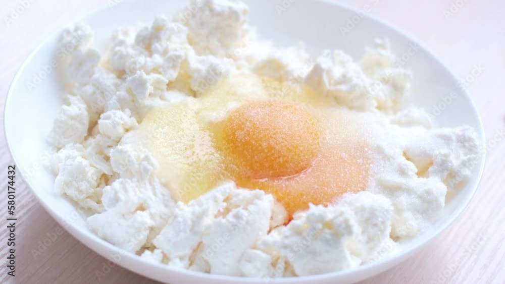 slow motion sugar sprinkled egg on plate with cottage cheese cooking cheesecake toppings pastry dough with cottage cheese breakfast stuffing for pies cheesecakes fritters syrniki home cooking slow motion sugar sprinkled egg on plate with cottage cheese cooking cheesecake toppings pastry dough with cottage cheese breakfast stuffing for pies cheesecakes fritters syrniki home cooking