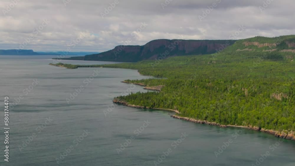Aerial view of blue water Lake Superior with green Canadian coastline Sleeping Giant Silver Islet Evergreen Trees Mountain Cliffs in background Aerial view of blue water Lake Superior with green Canadian coastline Sleeping Giant Silver Islet Evergreen Trees Mountain Cliffs in background