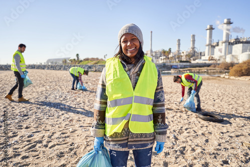 Young Latin activist looking camera holding garbage bag. Smiling woman standing with happy expression. Volunteer people cleaning plastic in nature. Concept environmental protection and sustainability.