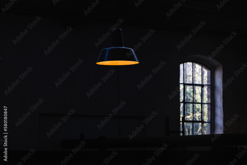 glowing ceiling lamp in front of a black wall