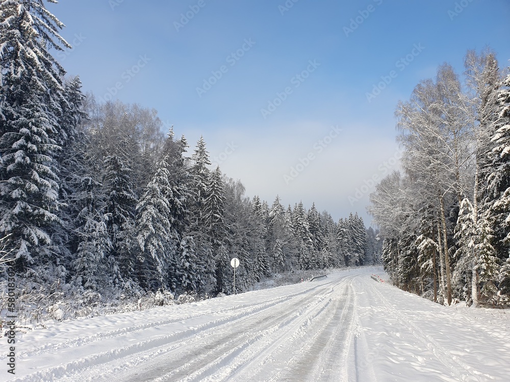 Automobile road through winter forest covered with snow Automobile road through winter forest covered with snow