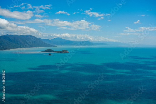Clear turquoise waters, coral reefs and blue skies with white fluffy clouds along the coastline of Cairns — Coral Sea, Far North Queensland, Australia