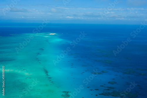 An aerial view of the coral reefs and clear turquoise waters surrounding Vlasoff Cay, a small white sand bar in the Great Barrier Reef — Coral Sea, Cairns  Far North Queensland, Australia © Jina Ihm