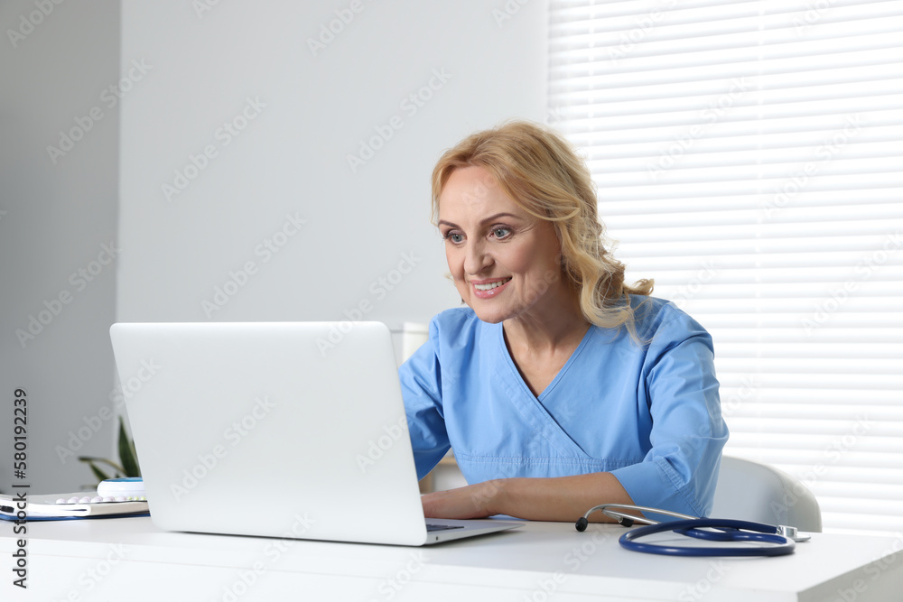 Doctor with laptop consulting patient in clinic. Online medicine concept Doctor with laptop consulting patient in clinic. Online medicine concept