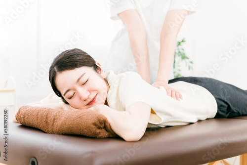 整骨院で腰を揉む整体師・マッサージ師・セラピストの女性（腰痛）
 photo