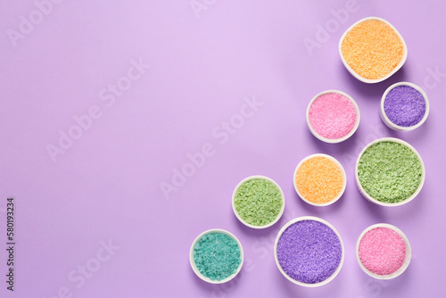 Different types of aromatic sea salt on purple background, flat lay. Space for text
